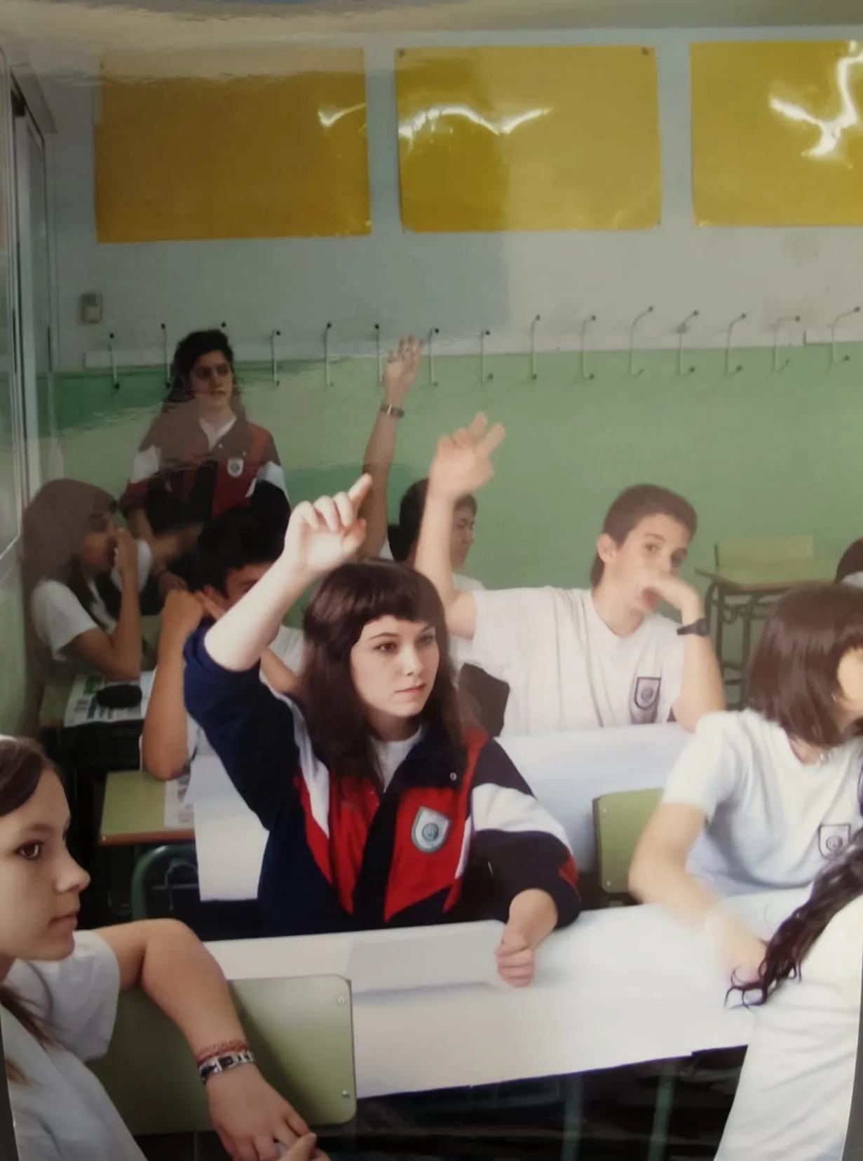 Alumnos de Secundaria levantando la mano en clase