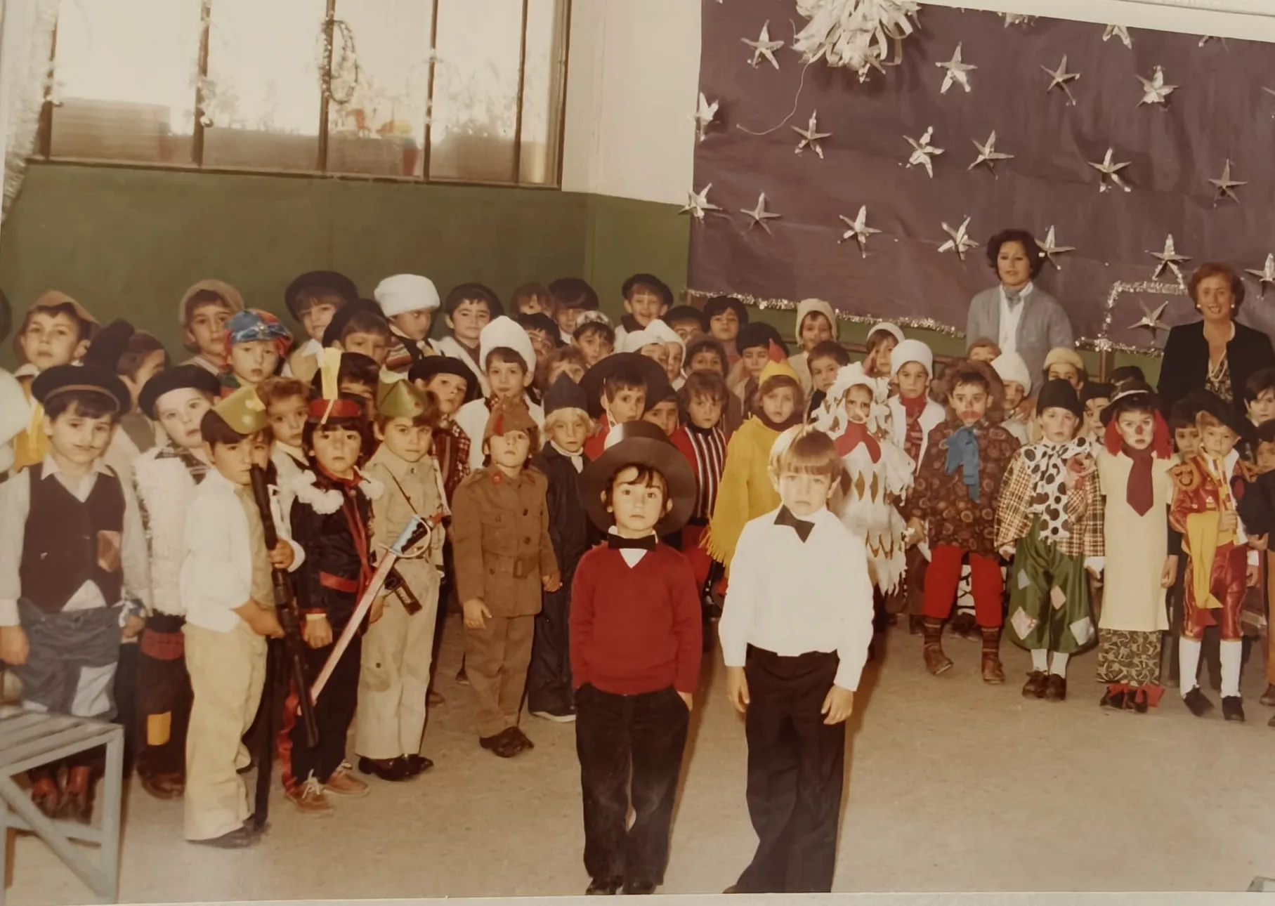 Una clase disfrazada con sus profesoras delante de un mural de estrellas