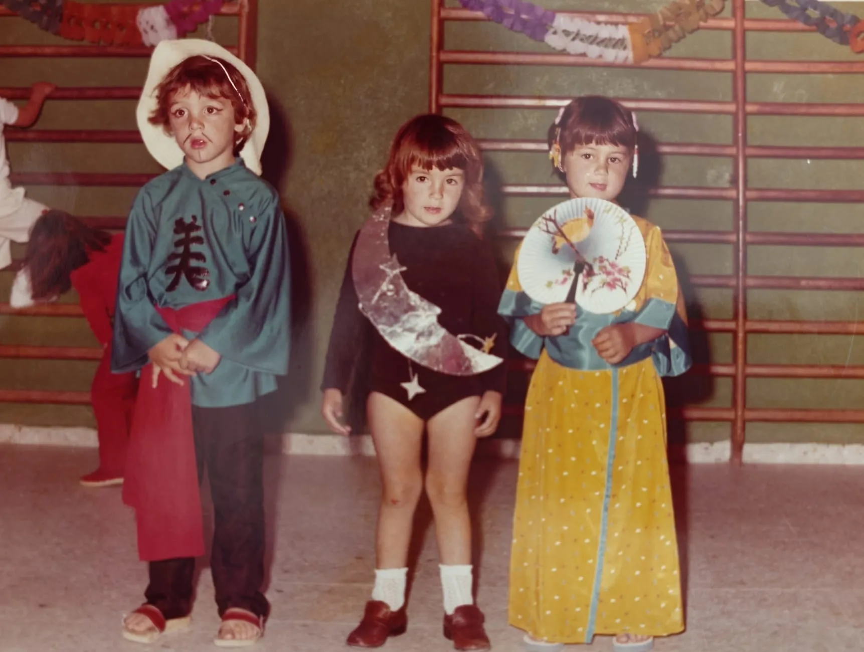 Tres niños de Infantil disfrazados en el gimnasio