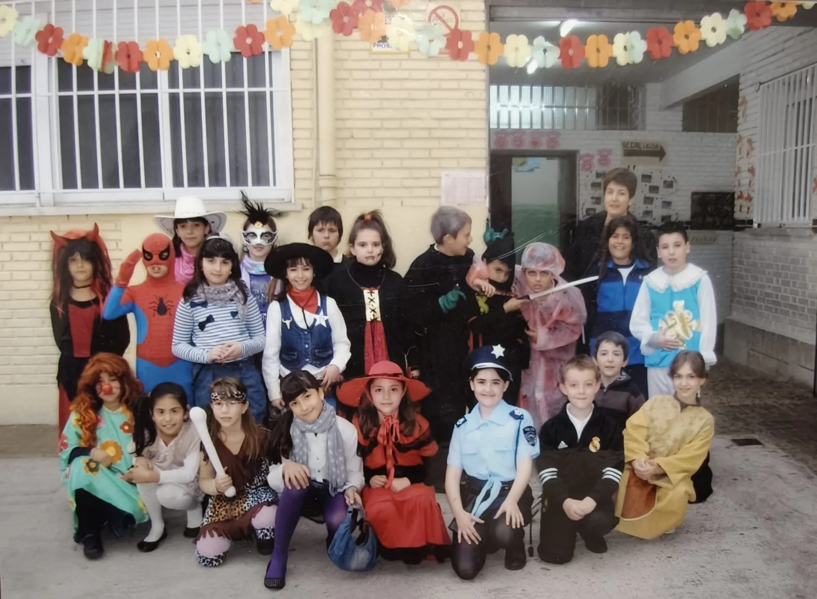 Alumnos disfrazados posando en el patio, delante del edificio