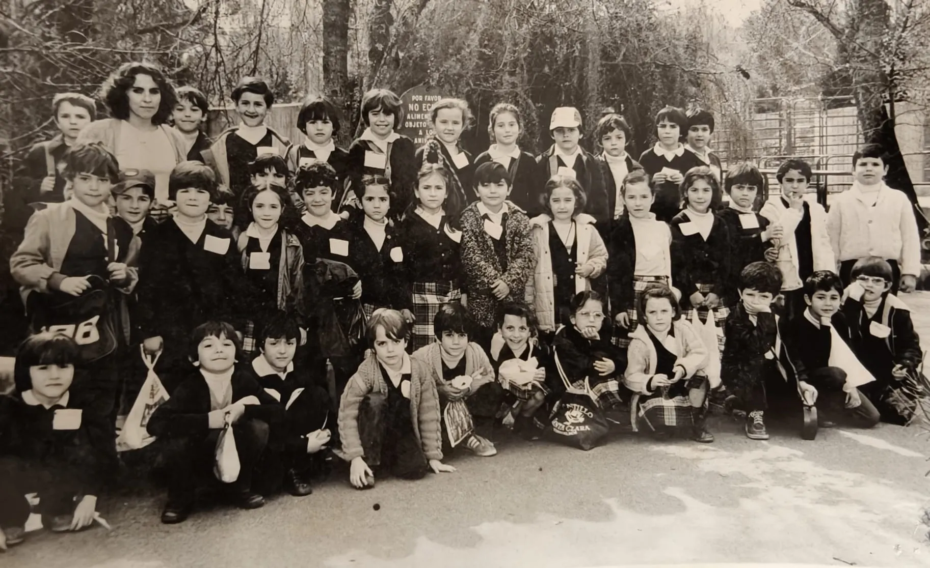 Foto de grupo en blanco y negro de una clase de excursión, con su profesora