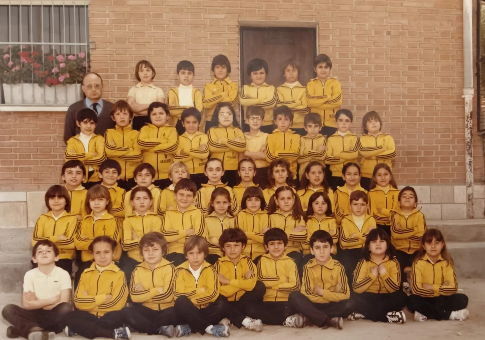 Foto de grupo de una clase con el chándal amarillo y su profesor