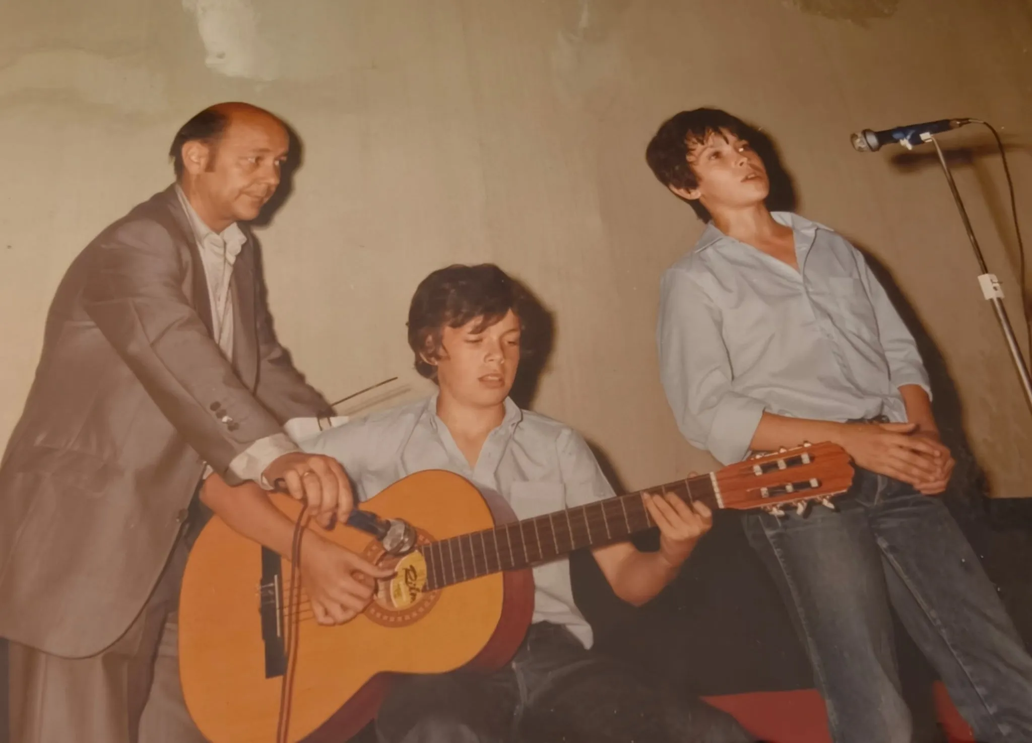 Un profesor con dos alumnos y una guitarra