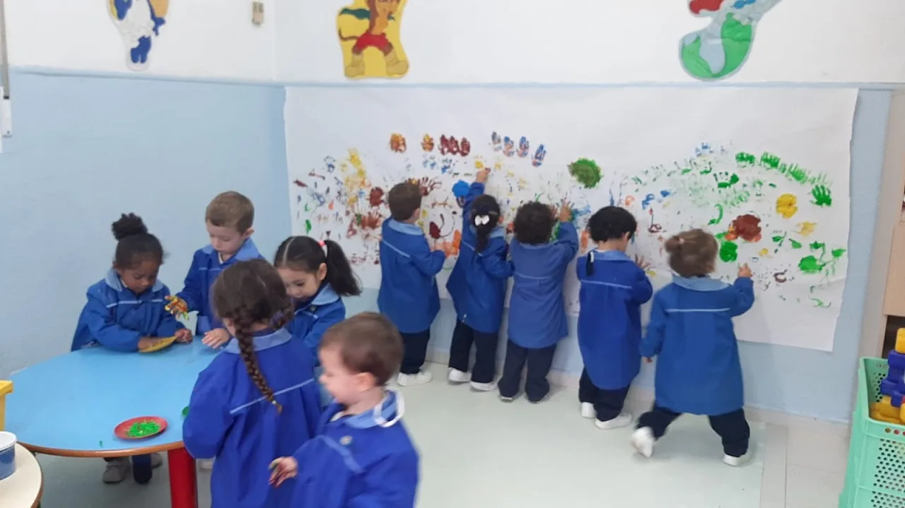Alumnos de Infantil pintando un mural con las manos